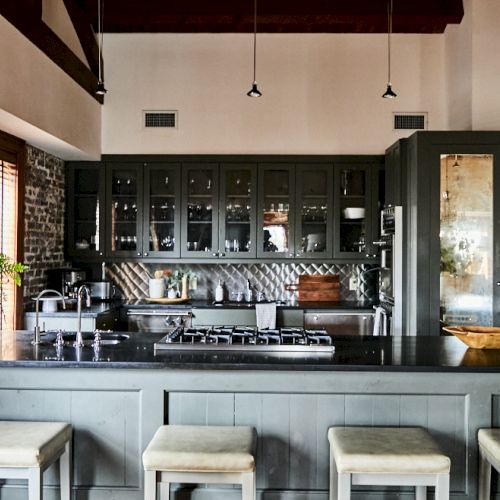 A modern cafe interior with a long counter, glass display, warm lighting, and seating along the back wall.